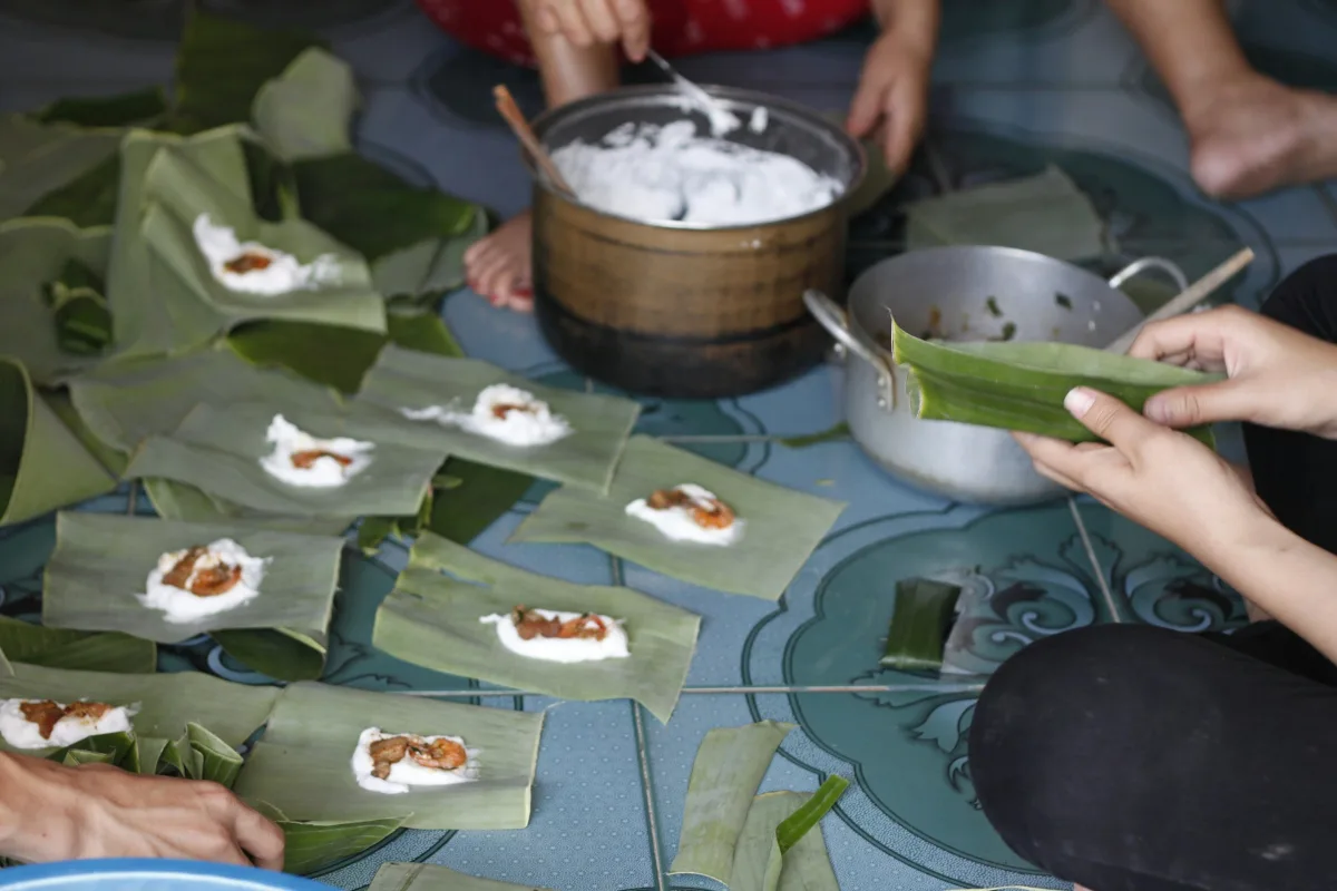 Những bàn tay gói bánh bằng lá chuối quanh nồi bột
