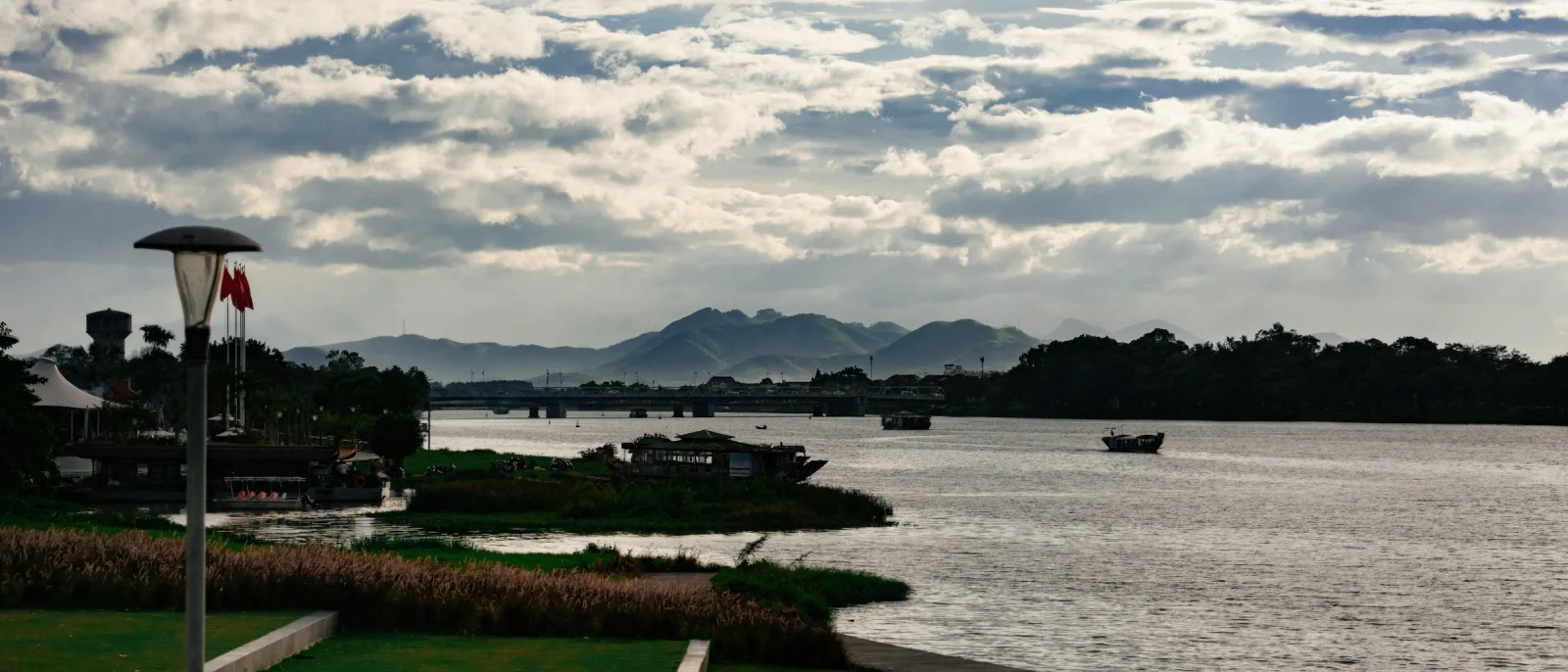 Sông Hương buổi sáng nhìn từ khách sạn ở Vỹ Dạ Huế, thuyền nhỏ trên mặt nước và dãy núi xa