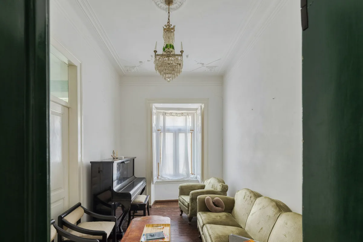 Phòng khách suite trần cao, đàn piano đứng, bộ sofa và đèn chùm pha lê