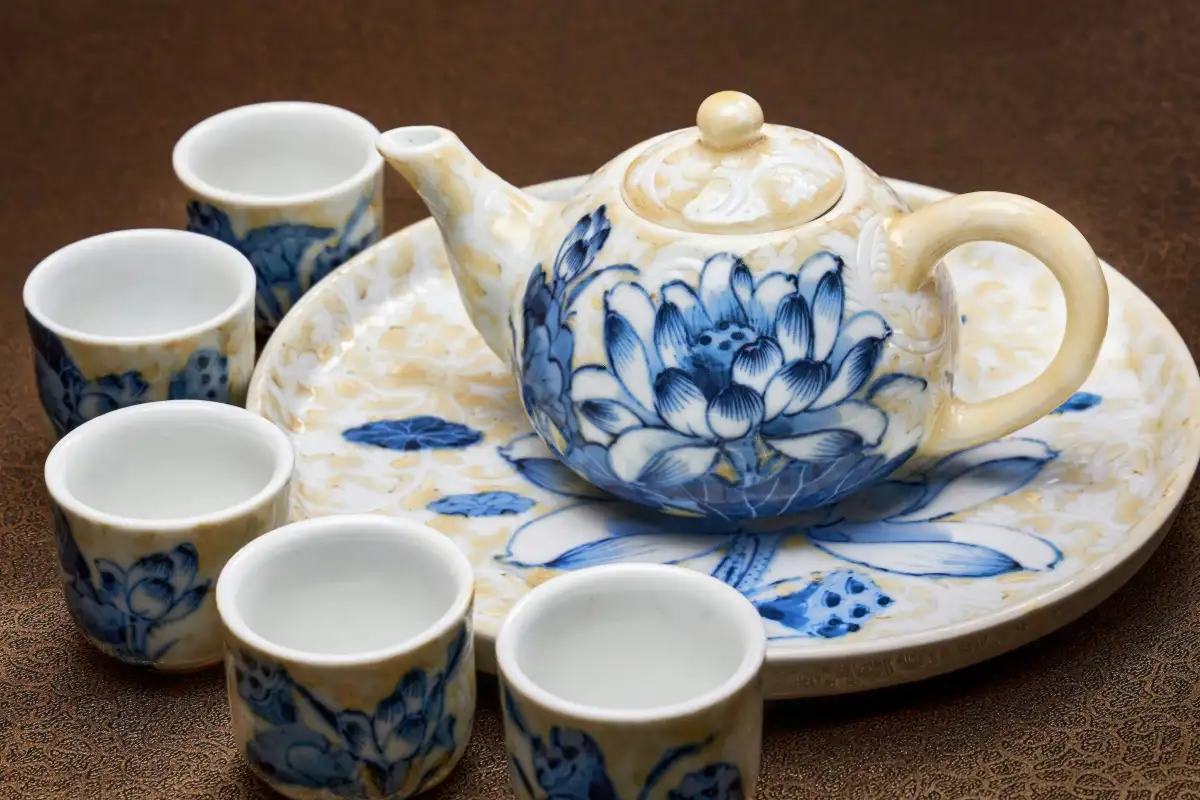 Bộ ấm chén sứ men lam vẽ hoa sen trên khay gỗ